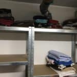 Decken und Handtücher liegen gefaltet auf Metallregalen, einige Plätze sind leer.