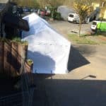 Weißes Zelt im Tierheim Siegen, sonniger Außenbereich, dahinter Hügel.