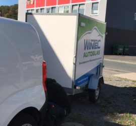 Weißer Lieferwagen mit Anhänger, geparkt an der Straße im Tierheim Siegen.