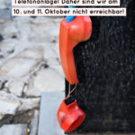 Zerbrochener roter Telefonhörer mit einem Hinweis auf Telefonausfälle im Oktober.
