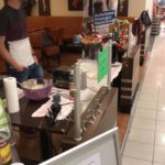 Mann am Tierheim Siegen Tisch mit Essen, Adoptionsschild im Einkaufszentrum.