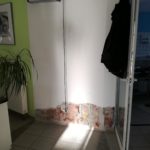 Sonnenlicht auf dem gefliesten Boden, abblätternde Farbe unter der offenen Tür.