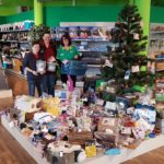 Drei Personen bei einem Weihnachtsbaum und Tierbedarf im Tierheim Siegen.