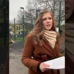 Frau in braunem Mantel mit Papieren draußen im Tierheim Siegen.