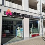 Schaufenster der Herz Apotheke mit großen Schaufenstern und Auslagen.