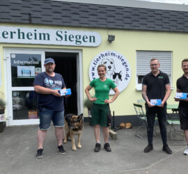 Vier Menschen und ein Hund mit Boxen vor dem Tierheim Siegen.
