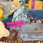 Korb mit handgefertigten Artikeln mit dem Schild "Jeder Teil 3€" in deutscher Sprache.