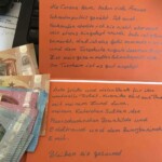 Orange handgeschriebene deutsche Karte mit Euro auf Tastatur und Papieren.