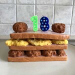 Sandwichkuchen mit Fleisch, Eischichten, Kerzen 1 und 8, Frikadellen.