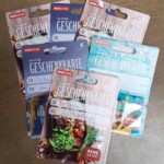 Sechs REWE-Geschenkkarten mit Notizen auf einem Holztisch im Tierheim Siegen.