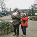 Zwei maskierte Personen in Mänteln halten kleine Hunde vor dem Tierheim Siegen.