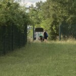 Drei Menschen und ein Hund an einem Zaun im Tierheim Siegen.